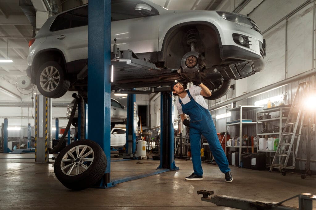 Mechanic working car suspension repair shop